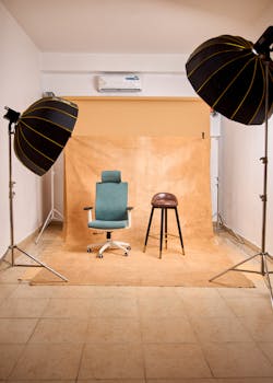 A professional photo studio setup with chairs, lighting, and backdrop ideal for content creation.